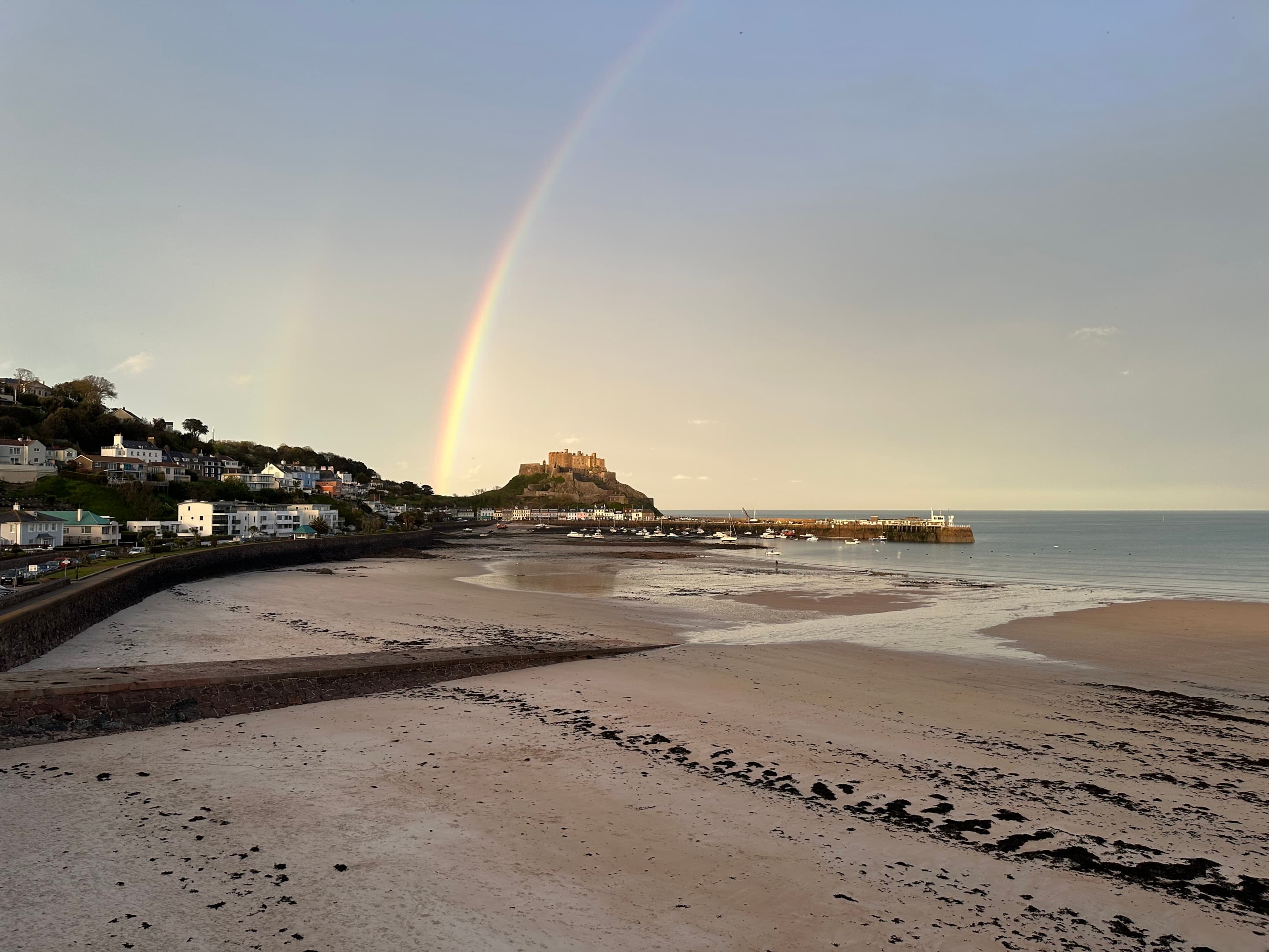 Rainbow above Mont Orgueil castle over Gorey beach at low tide, Jersey