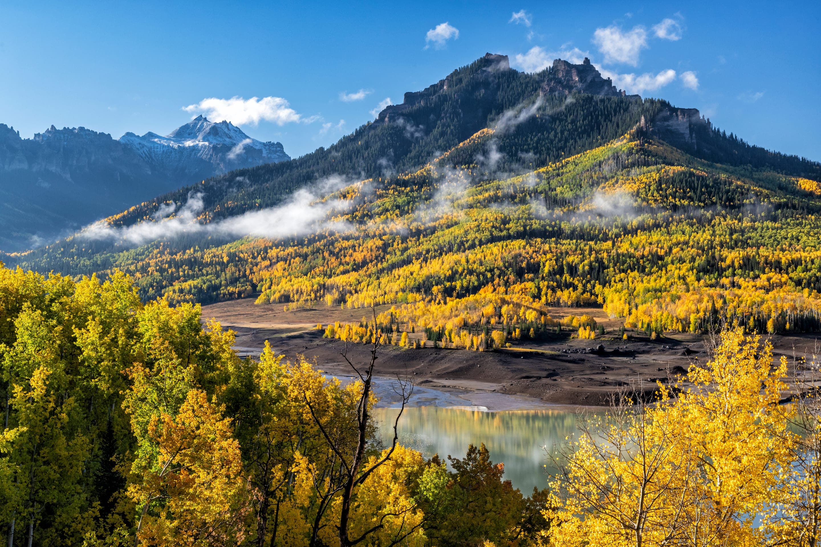 Alpine lake and mountain peak framed by autumn aspens